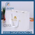 Elegante bolsa de ropa de papel blanco con estampado en caliente de logotipo de oro